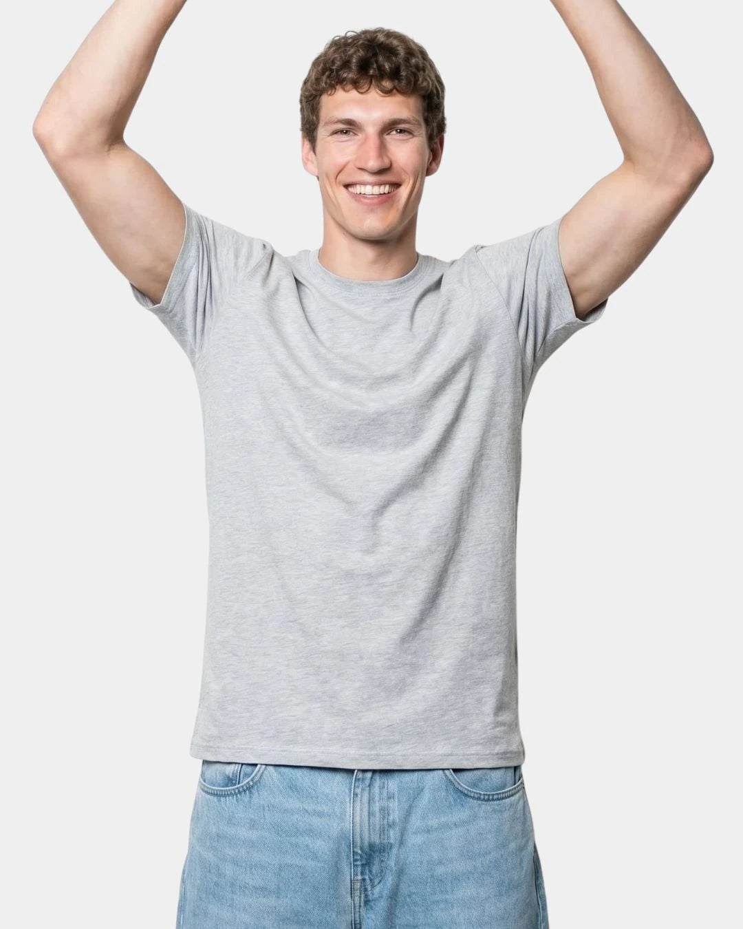 Derselbe Mann mit erhobenen Armen im T-Shirt von oneninetyfive, der Saum bleibt über dem Hosenbund